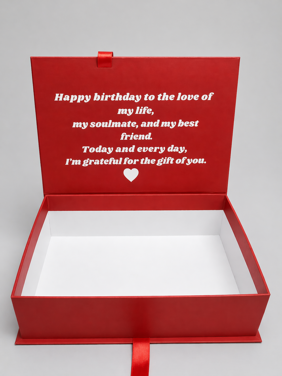 Red gift box with a heartfelt message on a gray background
