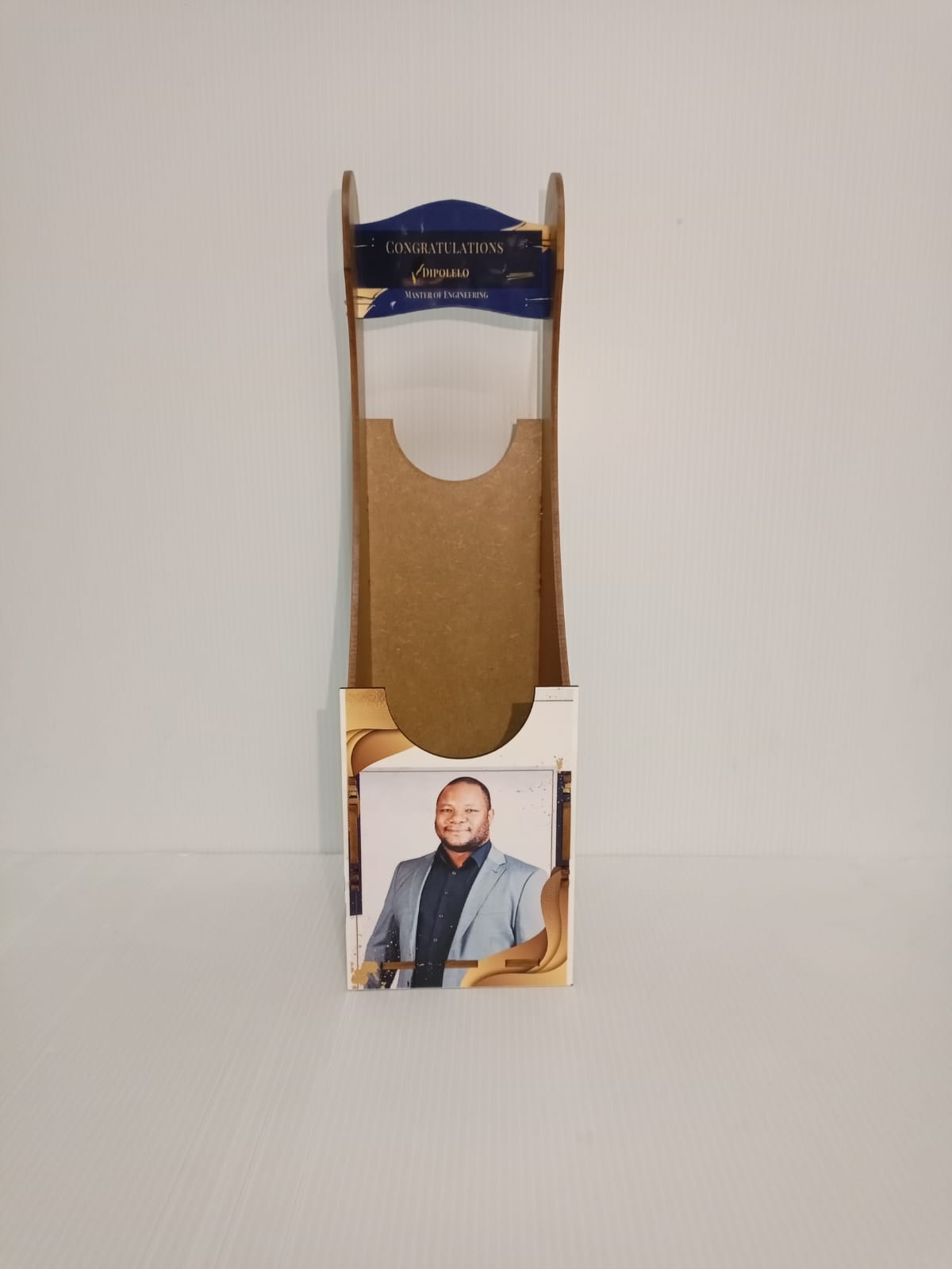 Cardboard packaging with a photo of a man and a brand label on a gray background