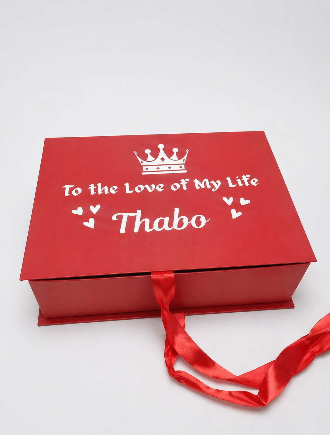 Red gift box with 'To the Love of My Life Thabo' text on a white background