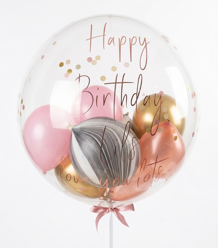 Clear balloon with pink, gold, and gray balloons inside, featuring 'Happy Birthday' text.