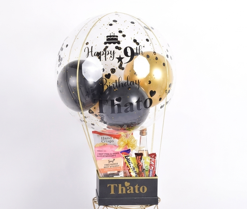 Decorative balloon basket with balloons and snacks on a white background