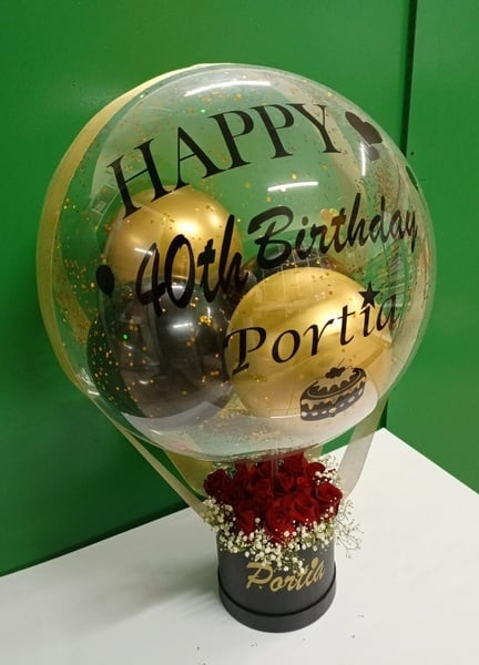 Decorative balloon with 'Happy 40th Birthday Portia' text and flowers on a green background