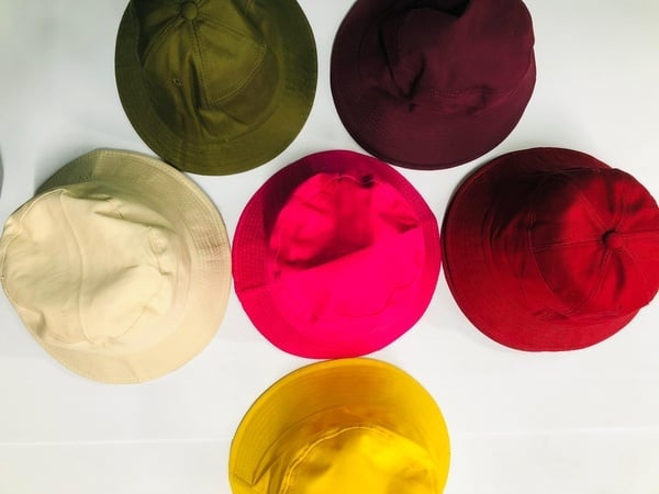 Six colorful bucket hats arranged in a circle on a white background.  Gifting in Pretoria.