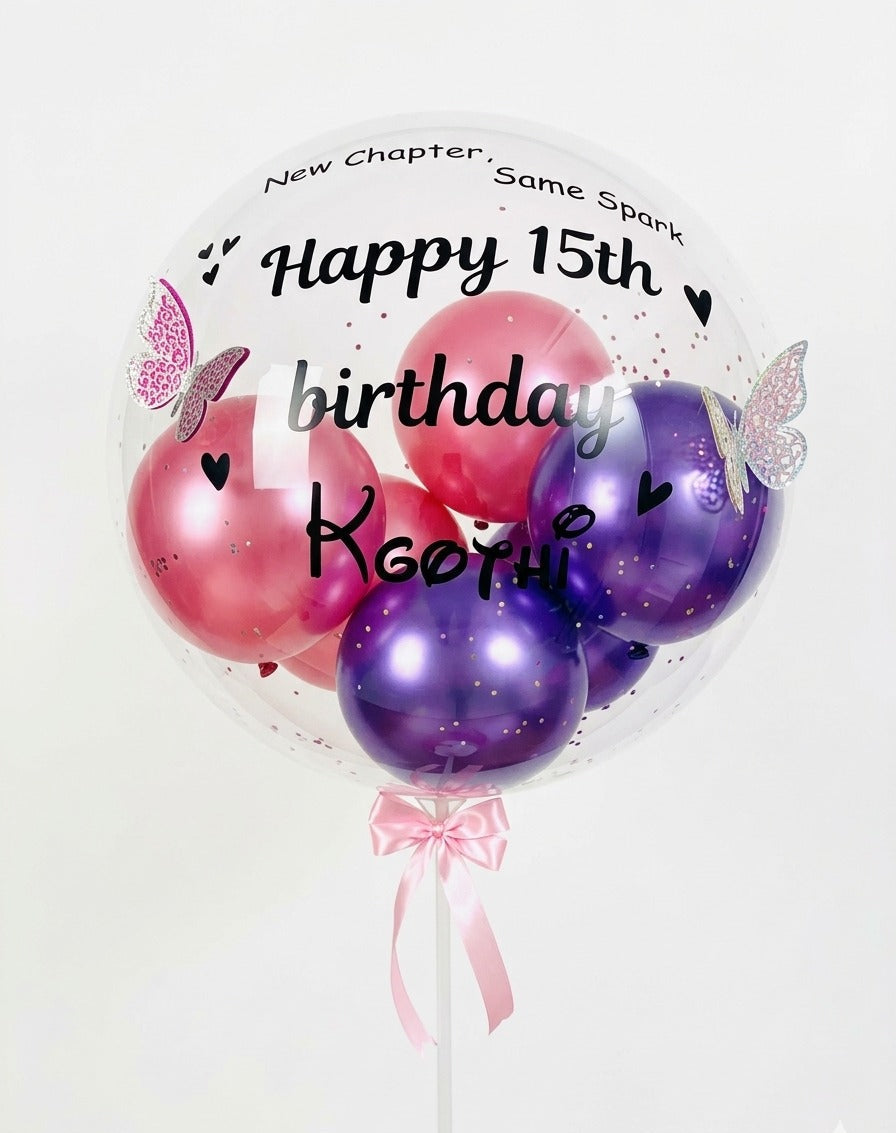 Bouquet of pink and purple balloons with decorative text on a white background