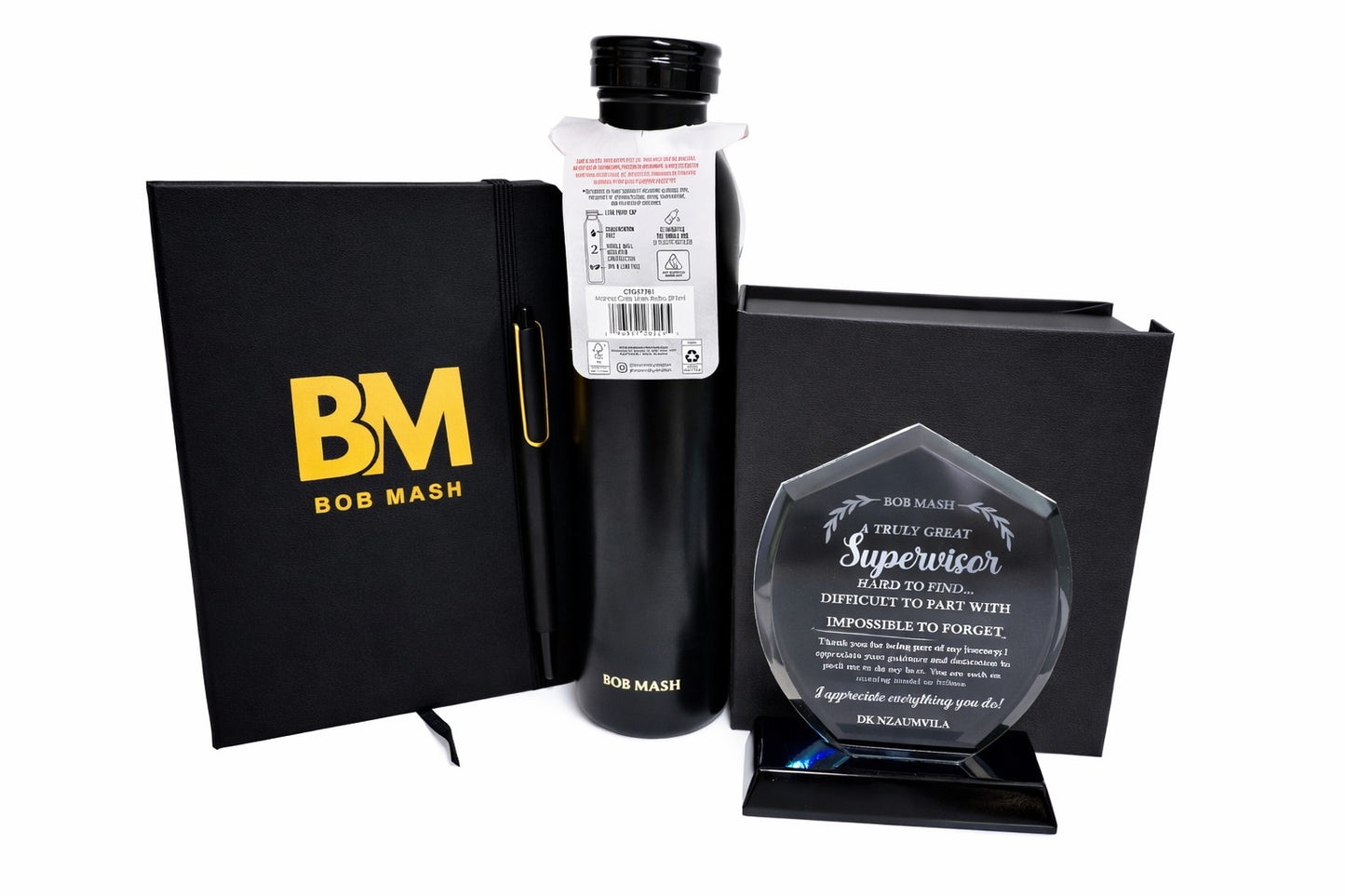 Bottle of Bob Mash with a black notebook and an award on a white background