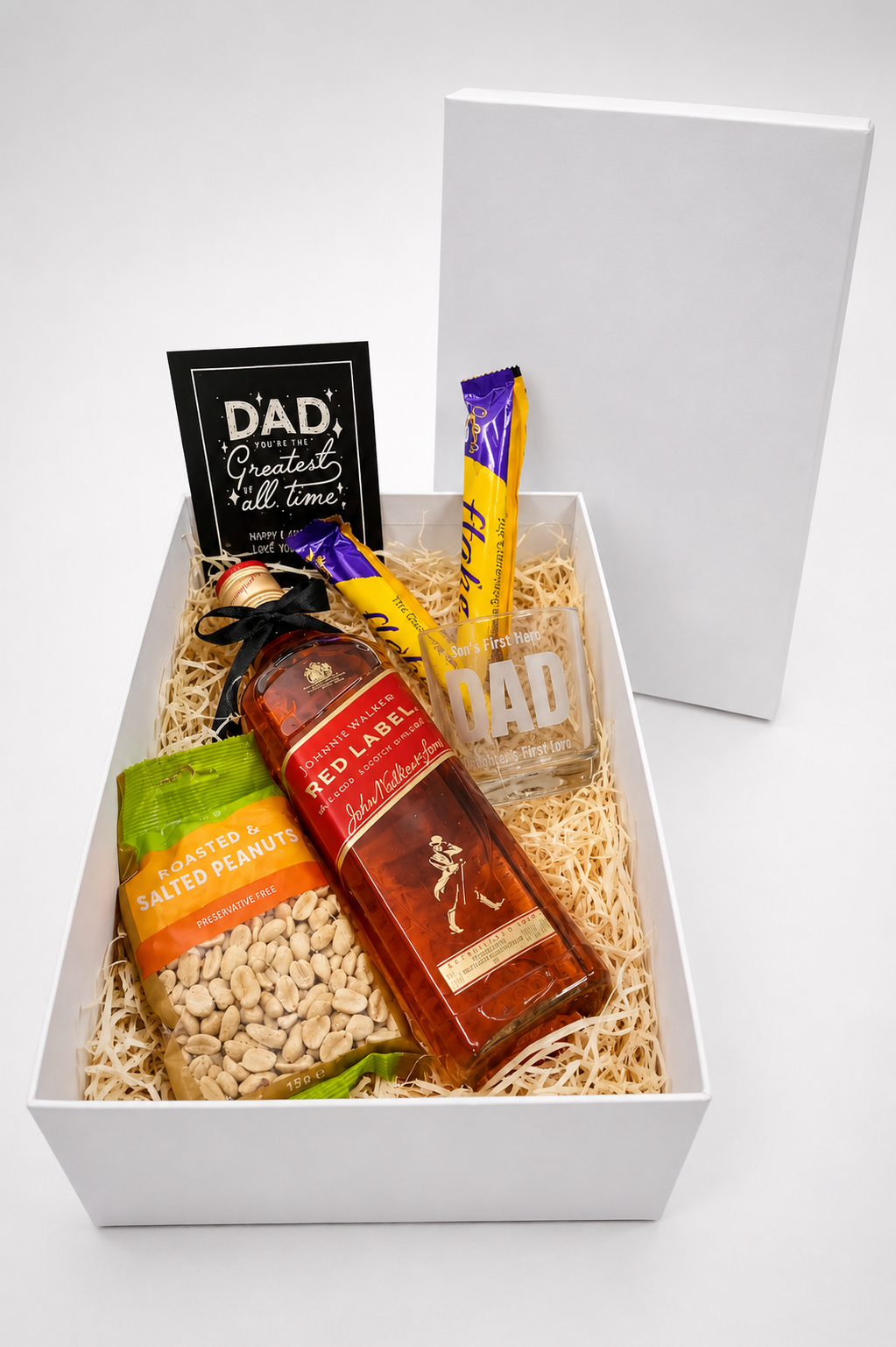 Gift basket with a bottle of Johnnie Walker Red Label whisky, snacks, and a card on a white background