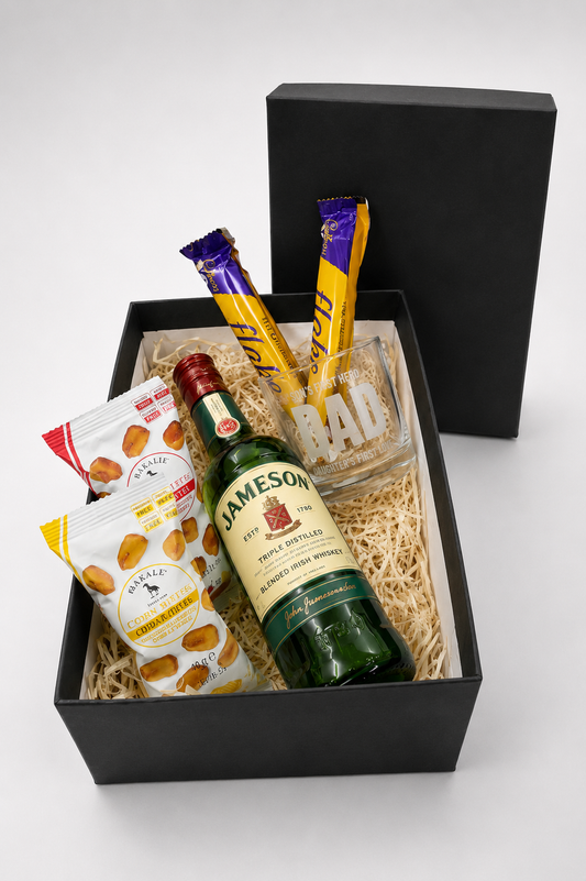 Gift basket with Jameson whiskey, snacks, and a glass on a white background