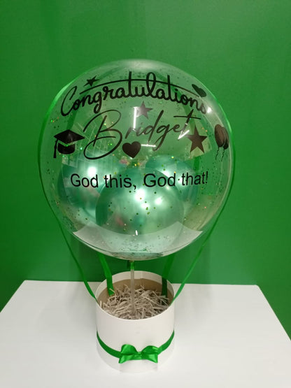 Decorative empty balloon gift hamper with text and a green bow 