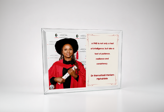 Person in graduation gown with framed quote on a white background