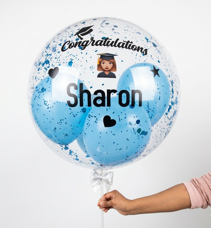 Balloon with 'Congratulations Sharon' text and a graduation cap design, held by a person.