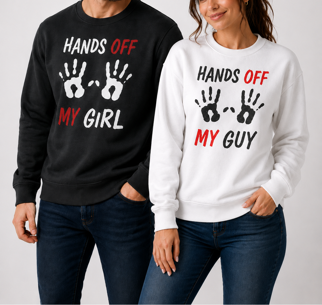 Man and woman wearing matching sweatshirts with 'HANDS OFF MY GIRL' and 'HANDS OFF MY GUY' text.