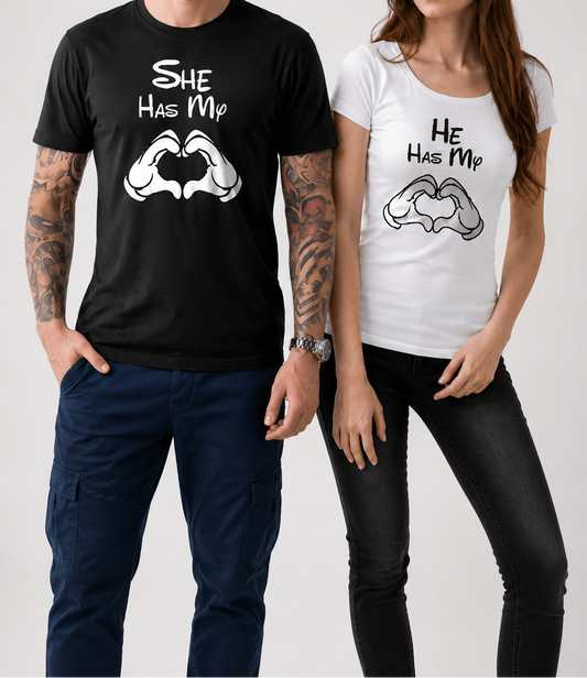 Man and woman wearing matching t-shirts with 'She Has My' and 'He Has My' text and graphic design.