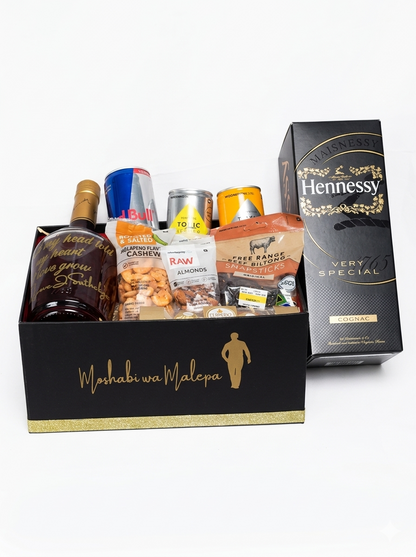 Gift basket with Hennessy bottle and snacks on a white background