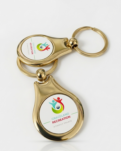 Gold keychain with a white tag featuring colorful graphics and text on a white background