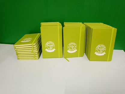 Stacks of green notebooks with a logo on a white surface and green background