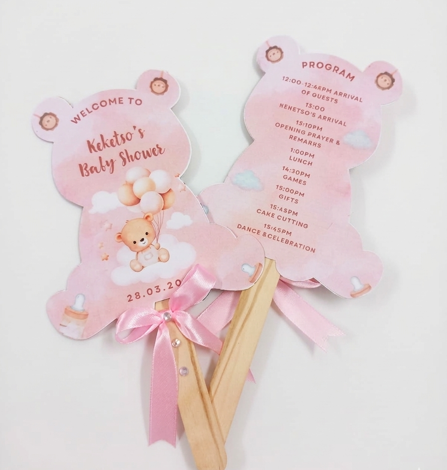 Pink baby shower fans with teddy bear design on a white background