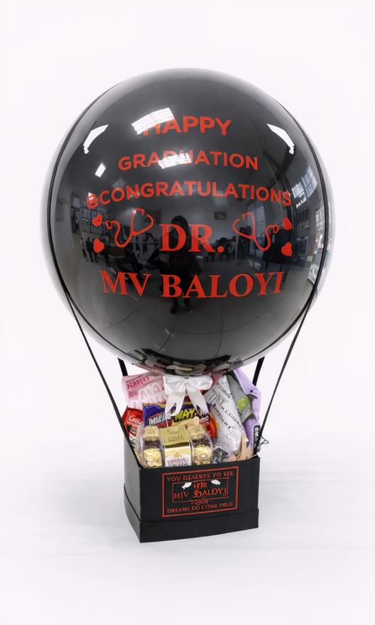Black balloon-shaped gift box with 'Happy Graduation Congratulations Dr. MV Baloyi' text, filled with snacks on a white background.