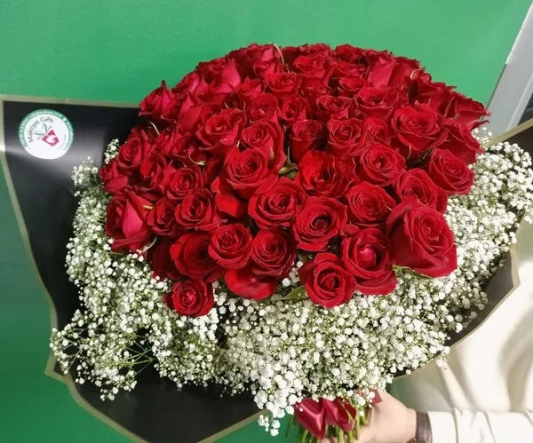 Bouquet of red roses with white
gyp on a green background