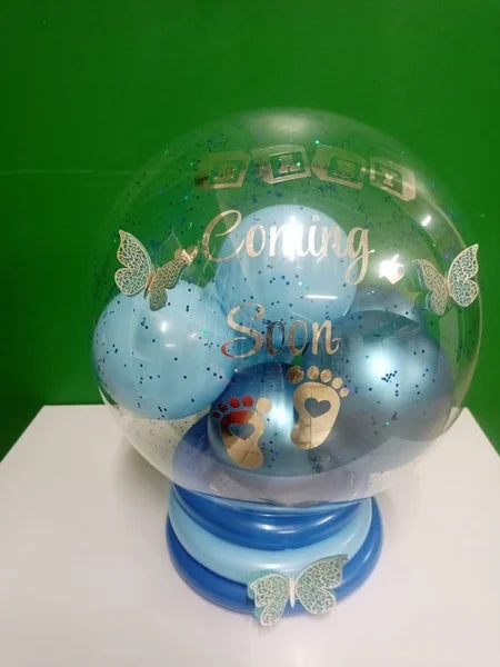 Decorative snow globe with 'Coming Soon' text and footprints on a green background