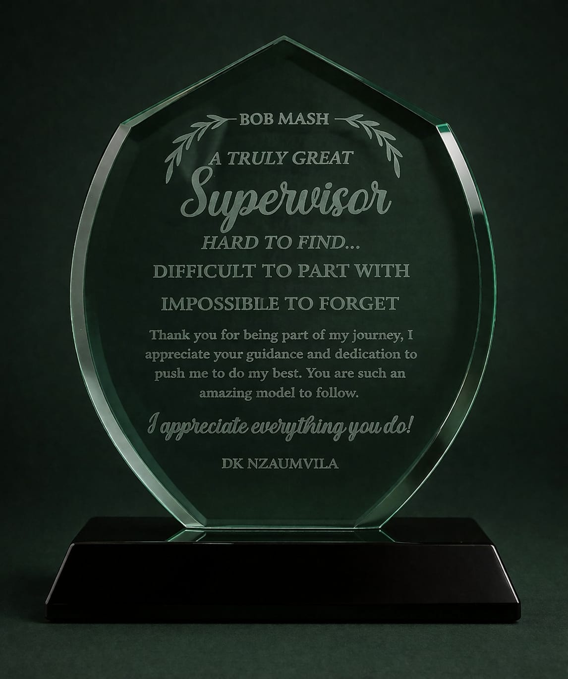 Glass award with engraved text on a dark background