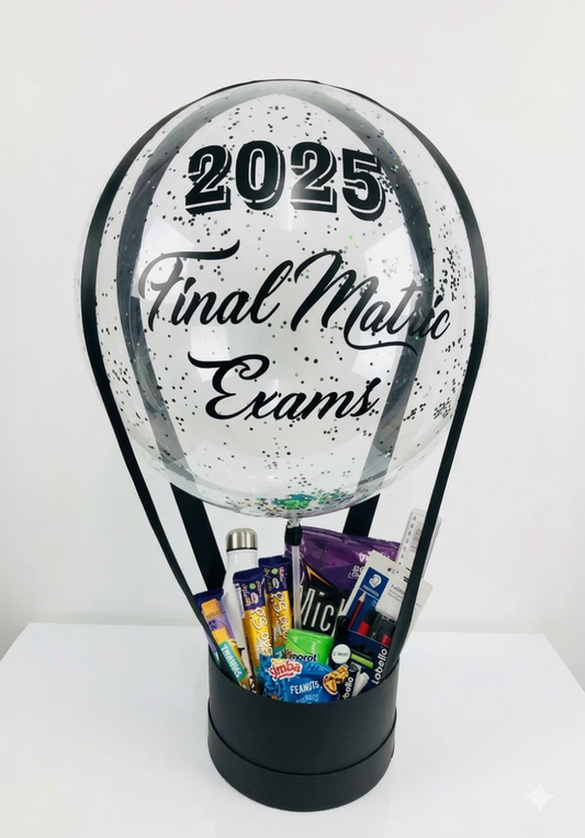 Clear snow globe with '2025 Final Matric Exams' text, filled with stationery and snacks.