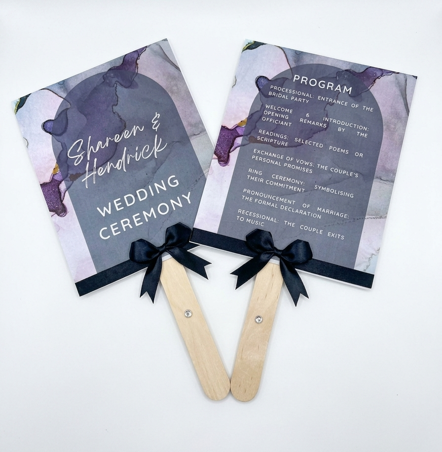 Two wedding ceremony programs on popsicle sticks with decorative ribbons against a white background.